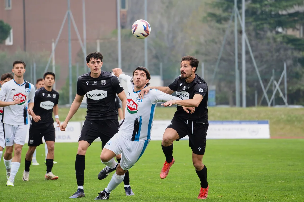 Anonymous left-back in defensive stance, making a block during a match, Maracanã stadium blurred in background, concentration and intensity visible