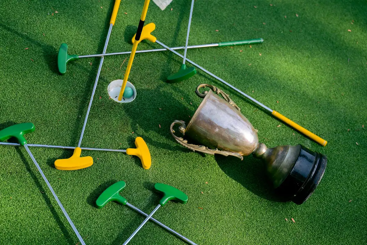 A trophy or championship moment, hands holding a symbolic victory emblem in the center of a stage, confetti or celebratory elements in soft focus around it, the symbol of triumph and achievement.