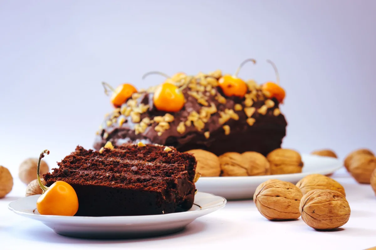 Multiple layers of sponge cake with meringue discs alternating, filled with rich cream and walnut crunch, topped with whipped cream and delicate egg threads, showcasing the towering height and intricate structure of this Brazilian classic.