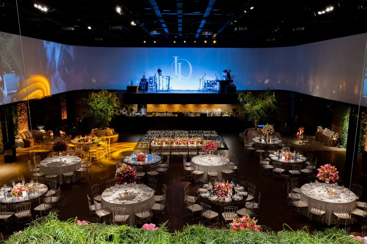 Elegant gala auction moment with anonymous auctioneer gesturing, bidders' raised hands in soft candlelight, luxury venue ambiance, formal attire visible