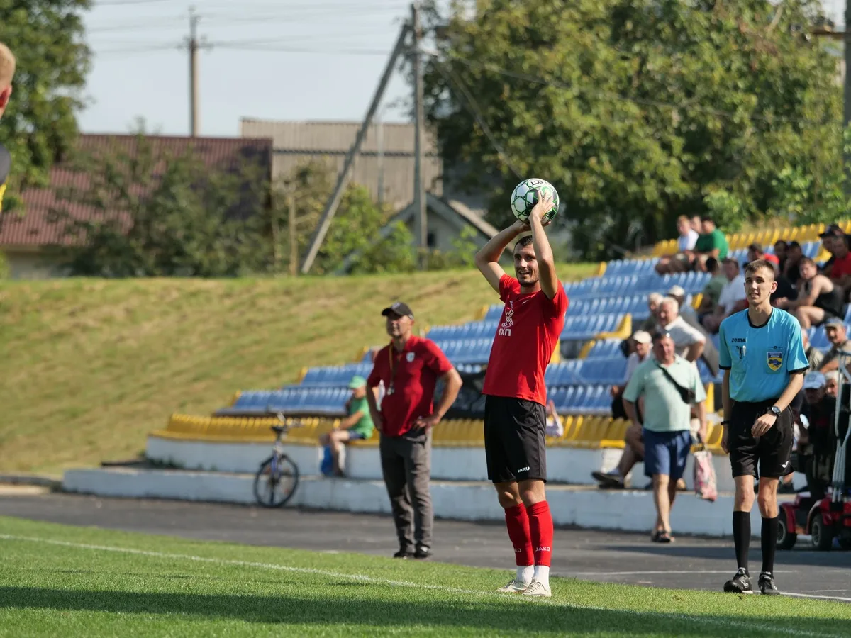 A young winger in white kit entering the pitch during a pre-season match, replacing another player mid-game, stadium lights illuminating the moment.
