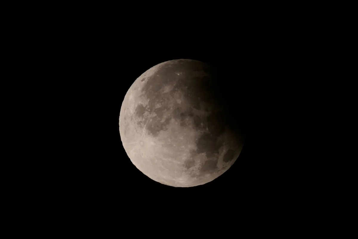 Earth's shadow cast in space with the Moon entering the umbra region, showing the geometric alignment of Sun, Earth, and Moon