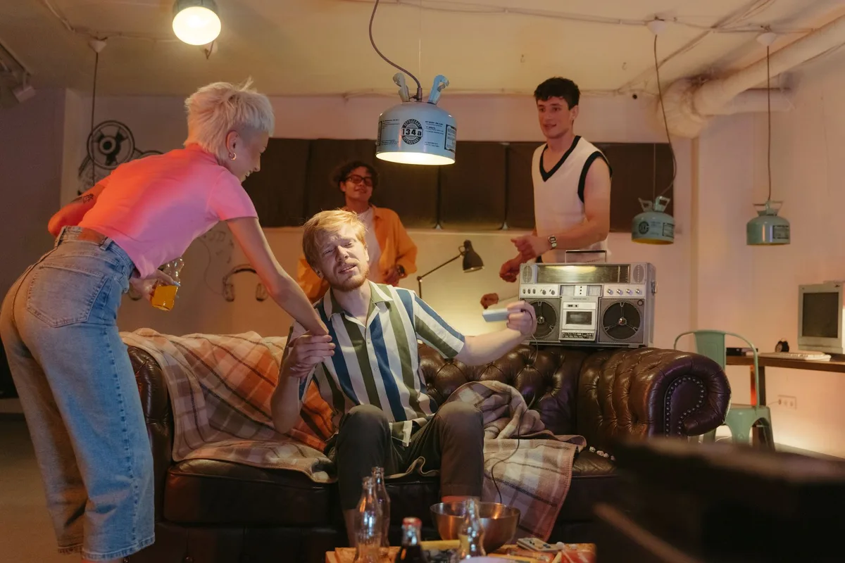 A television studio set with dramatic lighting, showing a modern living room interior with contemporary furniture, a moment of tense conversation between two characters, warm and cool tones contrasting, intimate domestic drama