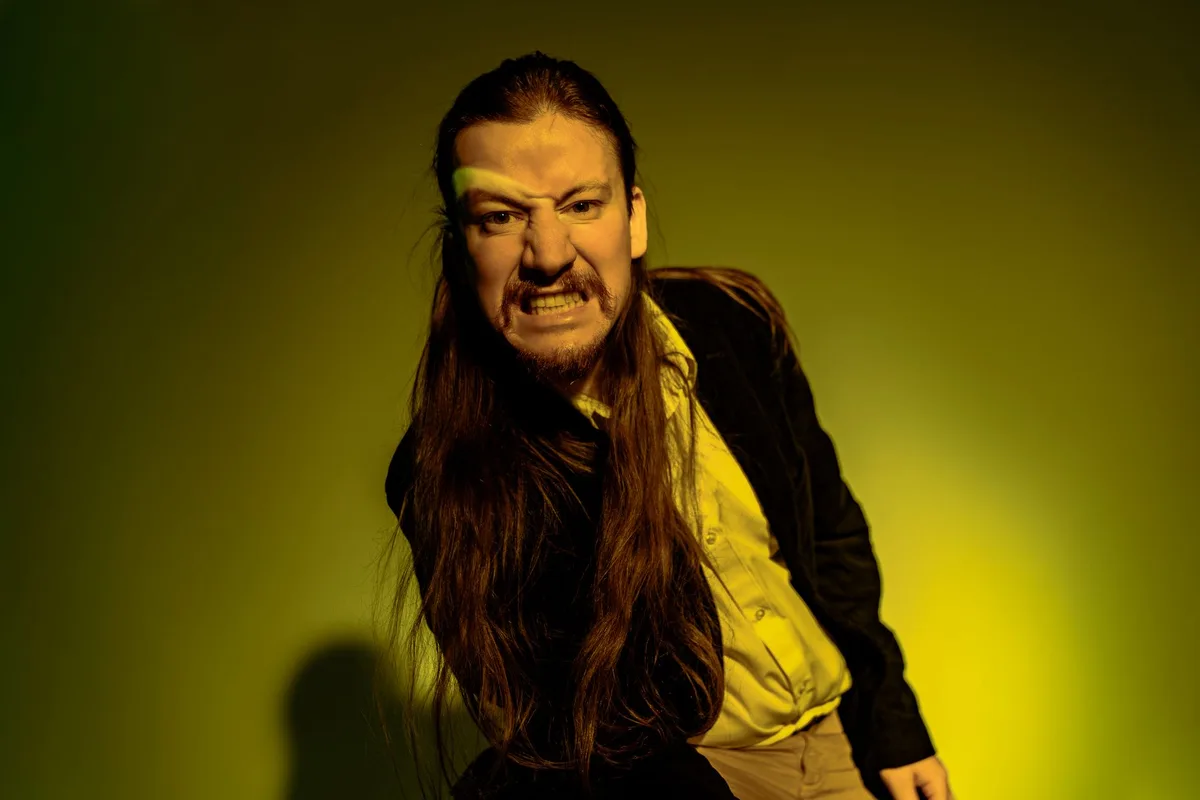 A woman's face showing conflicting emotions—determination and vulnerability—in dramatic lighting, eyes reflecting both hardness and pain, against a blurred corporate background