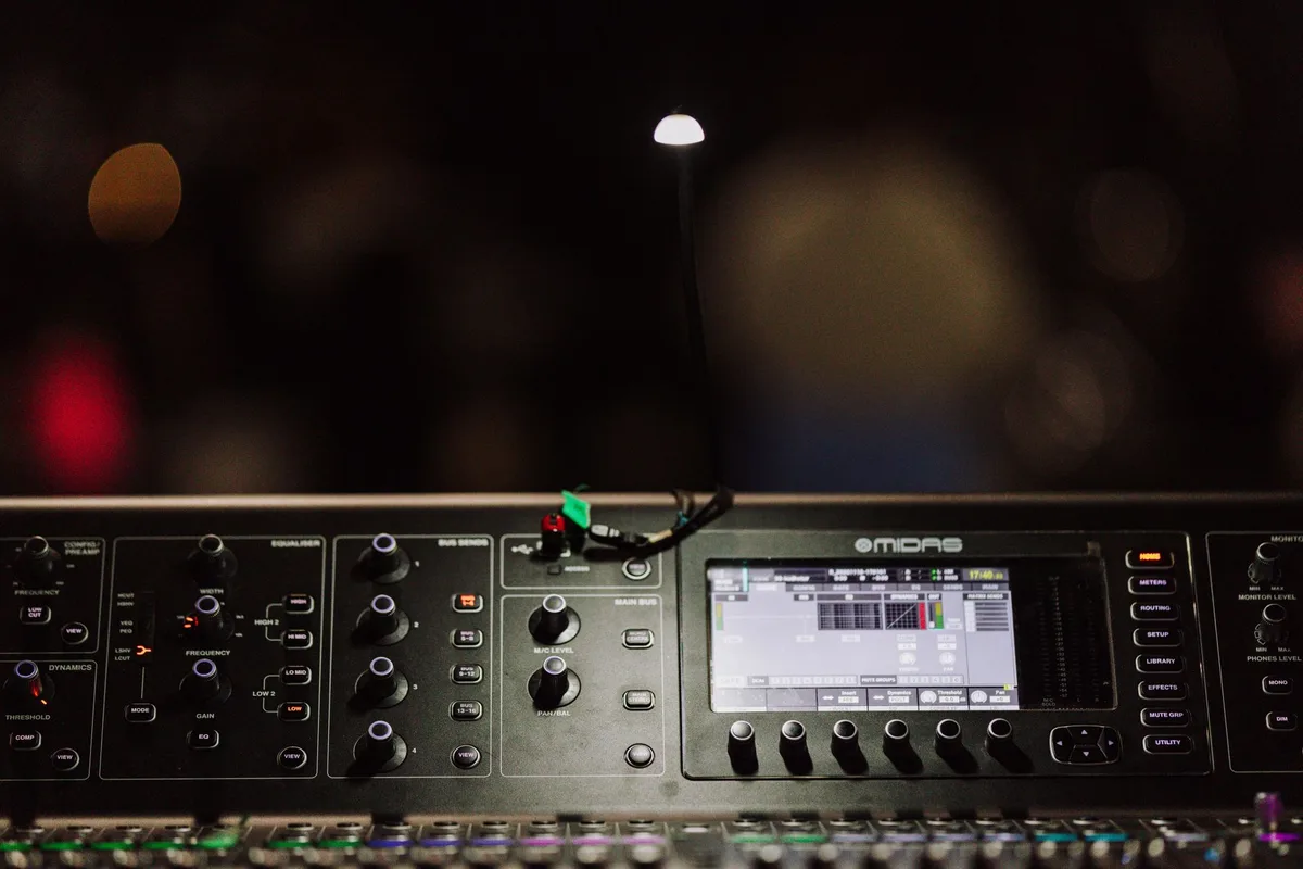 A recording studio setup with microphone, mixing console, and red-tinted lighting reflecting a bold new creative direction and intimate songwriting environment.