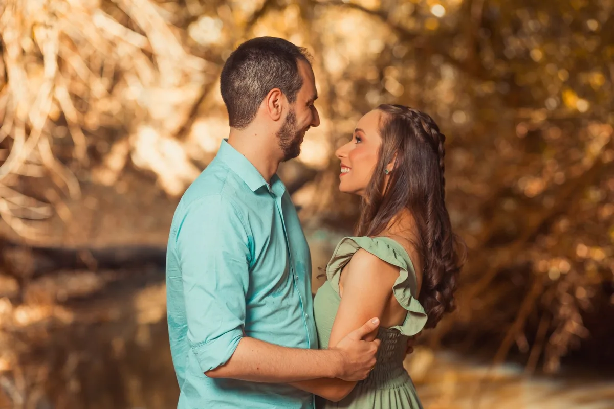 A couple silhouetted against soft warm lighting, hands reaching toward each other in an intimate moment, faces close but not visible, suggesting vulnerability and reconciliation in a private setting