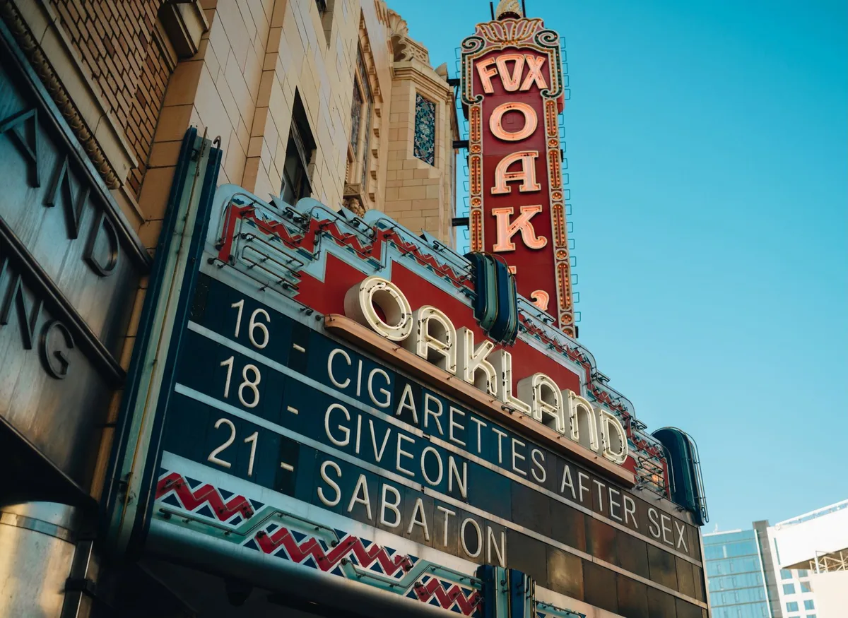 A theater marquee glowing at dusk with the play title illuminated, empty street in front, anticipation and warmth in the lighting, no people visible