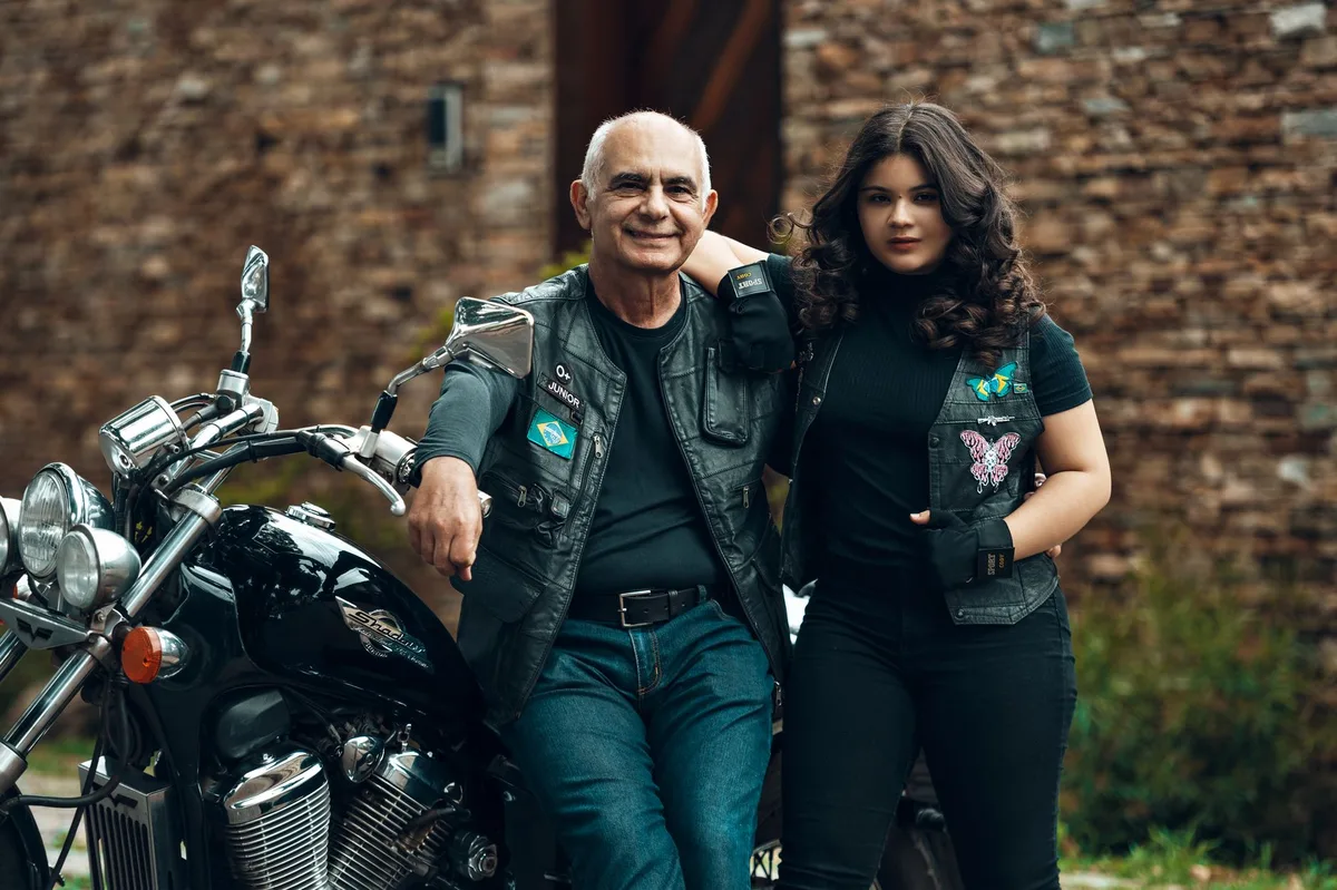 A worn leather jacket hanging on a chair in dim lighting, empty motorcycle club patches visible, a symbol of the original show's legacy