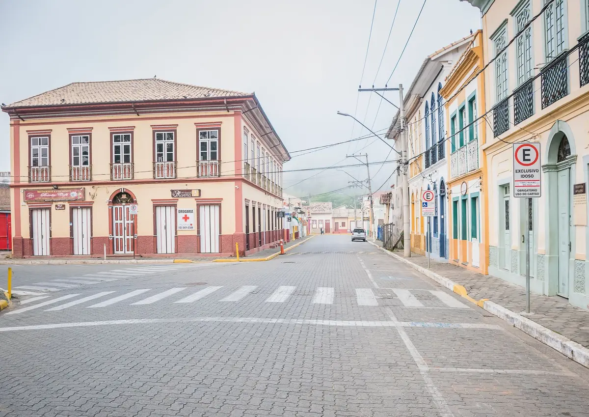 Street-level view of Centro Histórico Manaus with historic colonial architecture, colorful colonial buildings, river visible in distance, empty streets ready for transformation, anticipation of cultural activation
