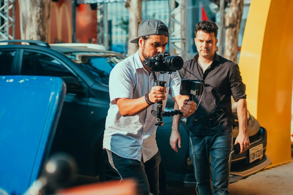 A film production set with movie cameras, lighting rigs, and empty director's chairs positioned for filming, suggesting imminent action and production energy