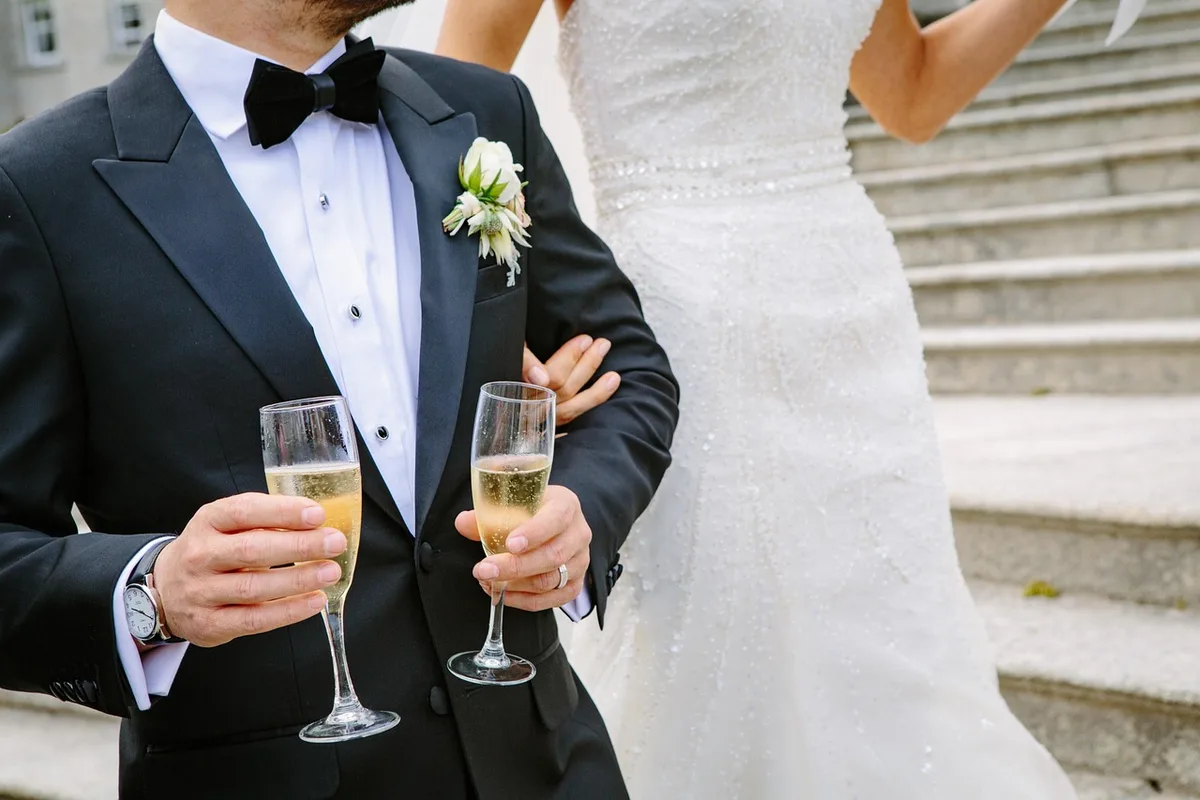 An intimate wedding ceremony chapel with candlelit ambiance, a quartet of string musicians playing in soft focus, blurred silhouettes of family members in the pews, golden light filtering through windows, emotional and serene atmosphere