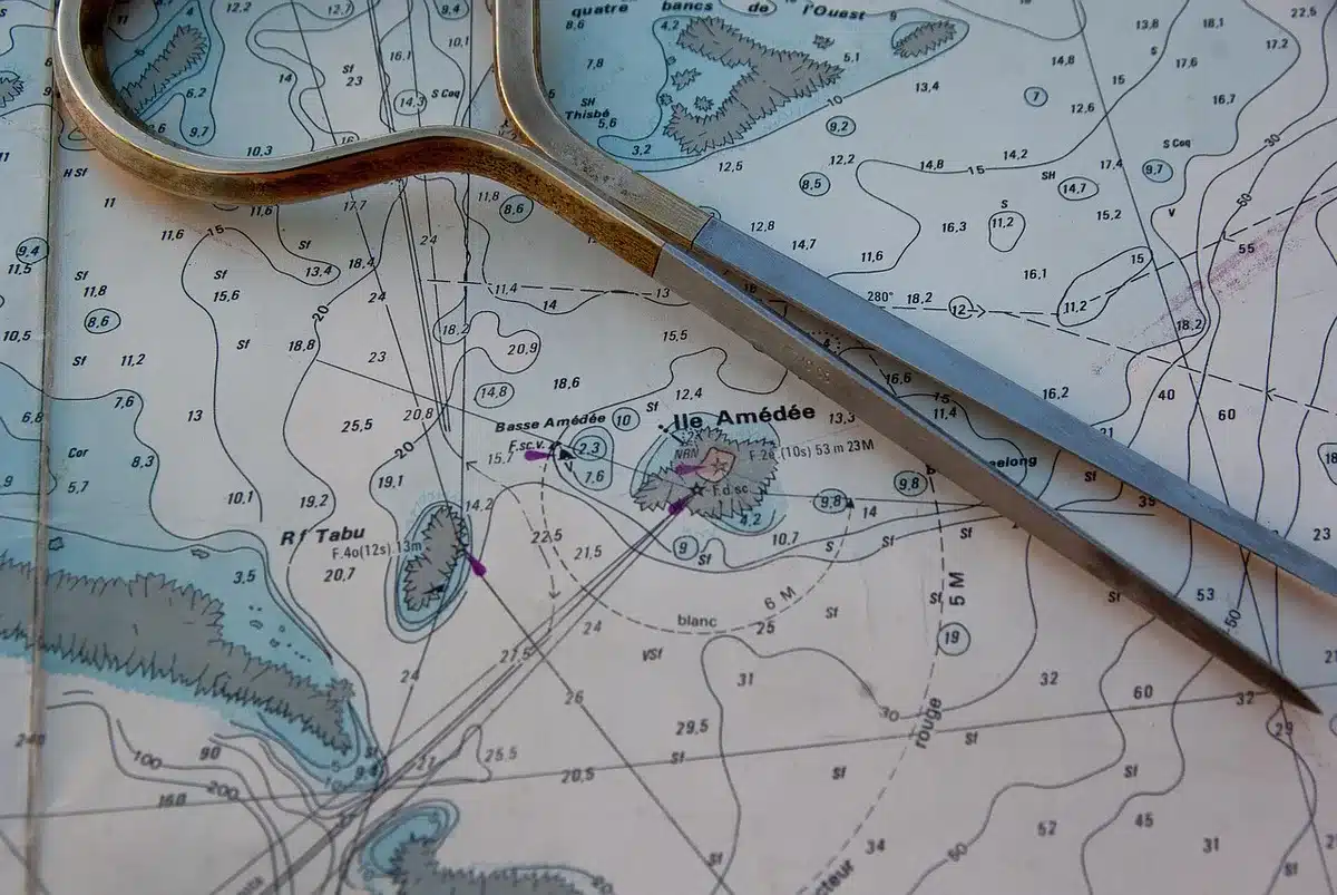 empty navy office desk with a vintage navigation chart and unbranded sextant on it