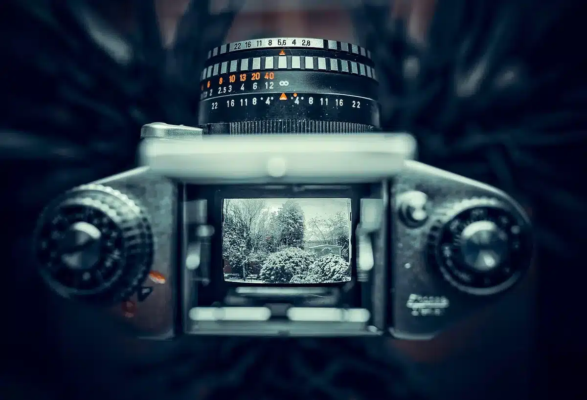 Empty studio with a single vintage camera on a wooden table under soft spotlight, dust motes visible