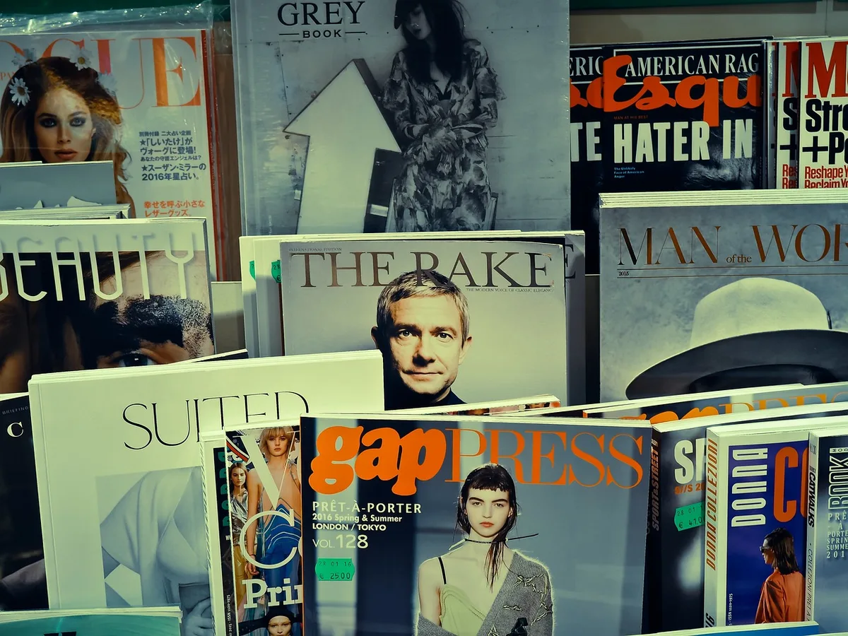 Magazine cover featuring a woman with flowing dark hair, soft lighting, neutral background, professional portrait style
