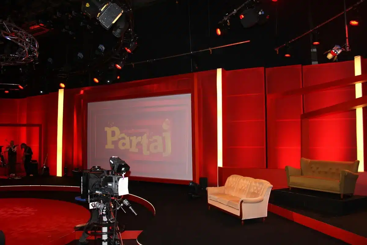 empty TV studio with two anonymous actresses rehearsing a dramatic scene, distant silhouettes, warm stage lights