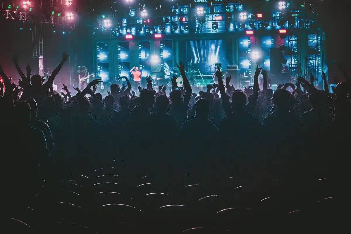 Empty concert stage with 360-degree setup, single spotlight illuminating the stage floor, ready for performance