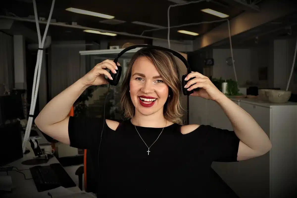 Two women in modern studio setting with professional lighting, one gesturing expressively during conversation, contemporary podcast environment