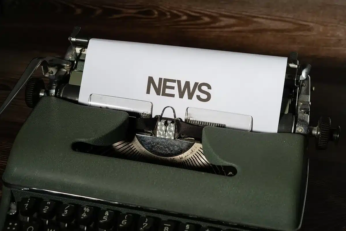 Placa ou símbolo da GloboNews em estúdio, com profissionais ao fundo em posição de trabalho, representando a estrutura editorial