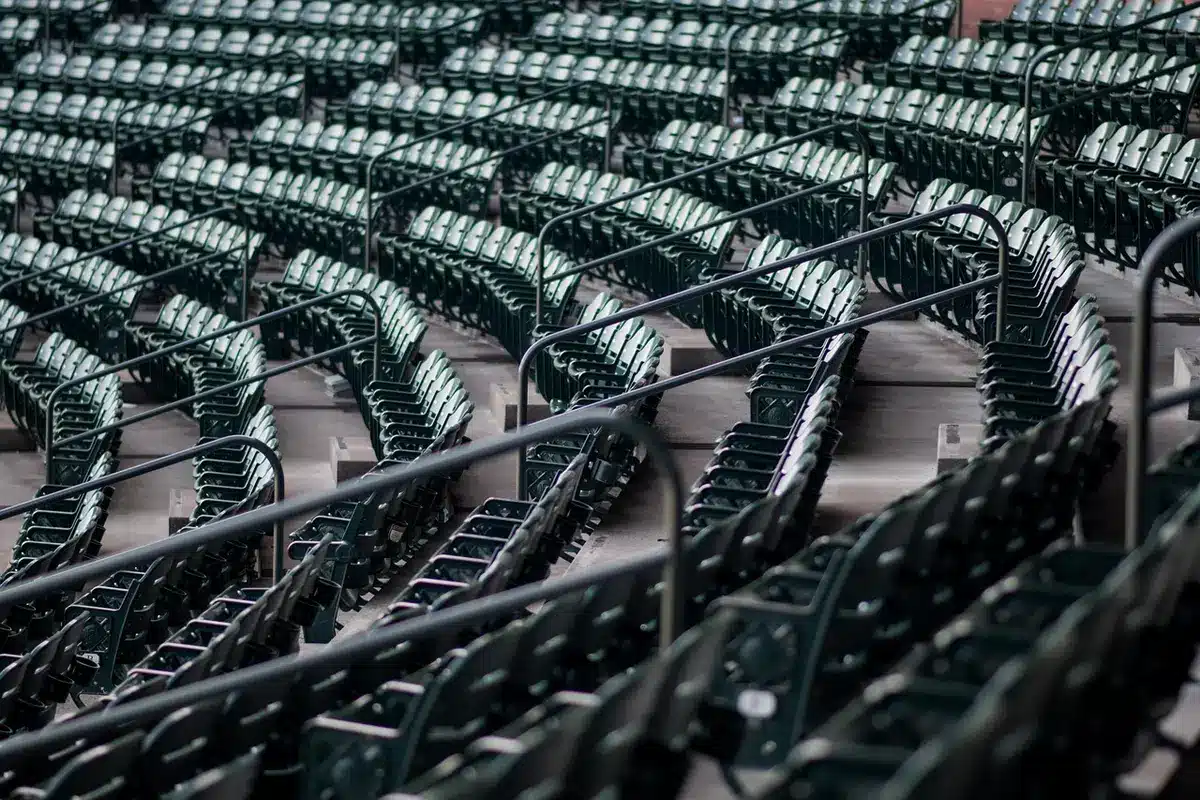 An empty stadium corridor with harsh shadows and a lone chair in dim light, suggesting the end of a campaign