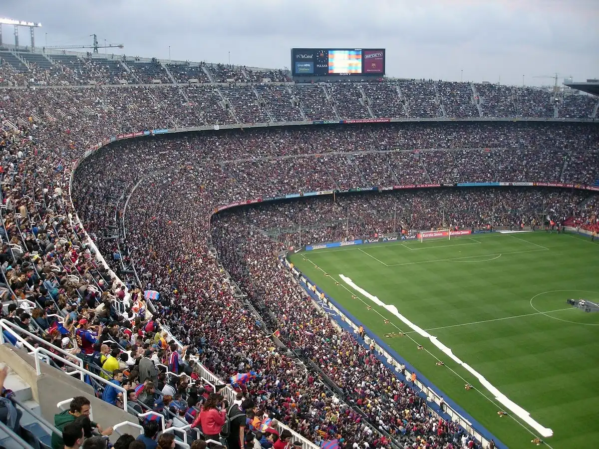Estádio de futebol suíço com torcida, campo bem cuidado, bandeiras suíças, atmosfera de partida profissional