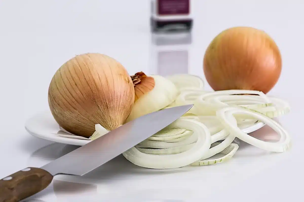 Amateur chef recording a video in a home kitchen, preparing a colorful dish, natural light streaming through windows, focused expression capturing the submission moment