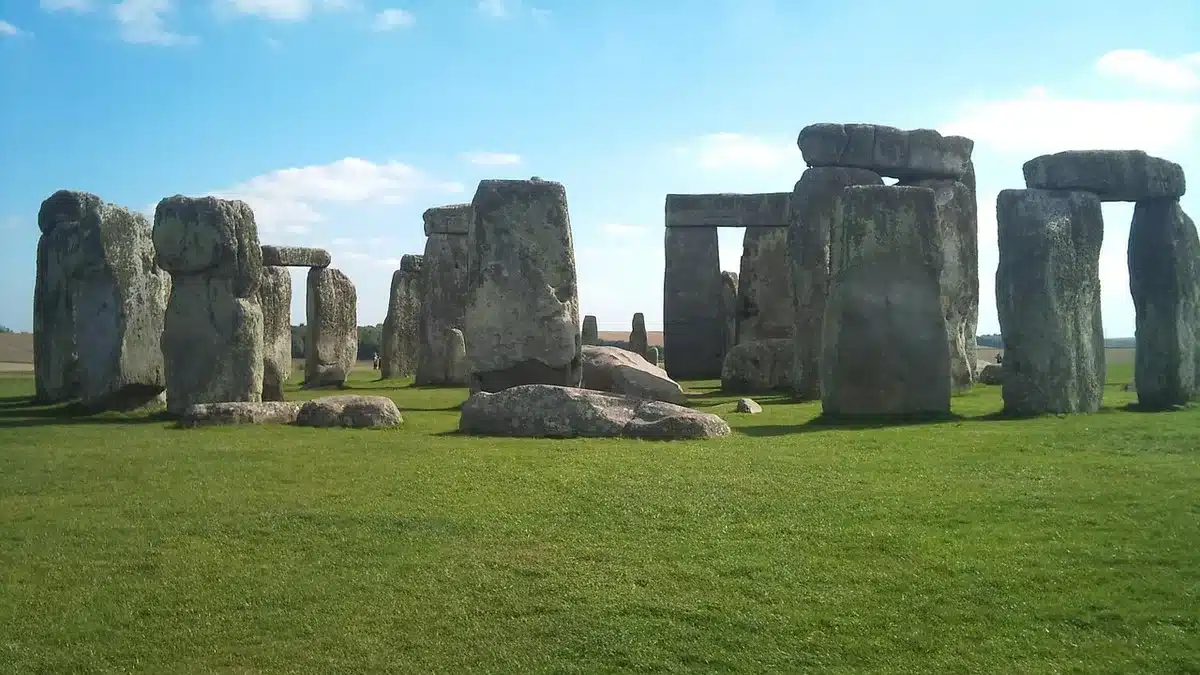 Stonehenge ao entardecer com luz dourada, monumento antigo em primeiro plano contra céu dramático