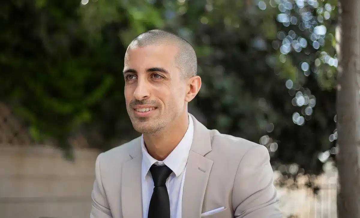 A private equity businessman in professional attire at a luxury event or business setting, sophisticated and understated elegance, corporate environment with soft lighting