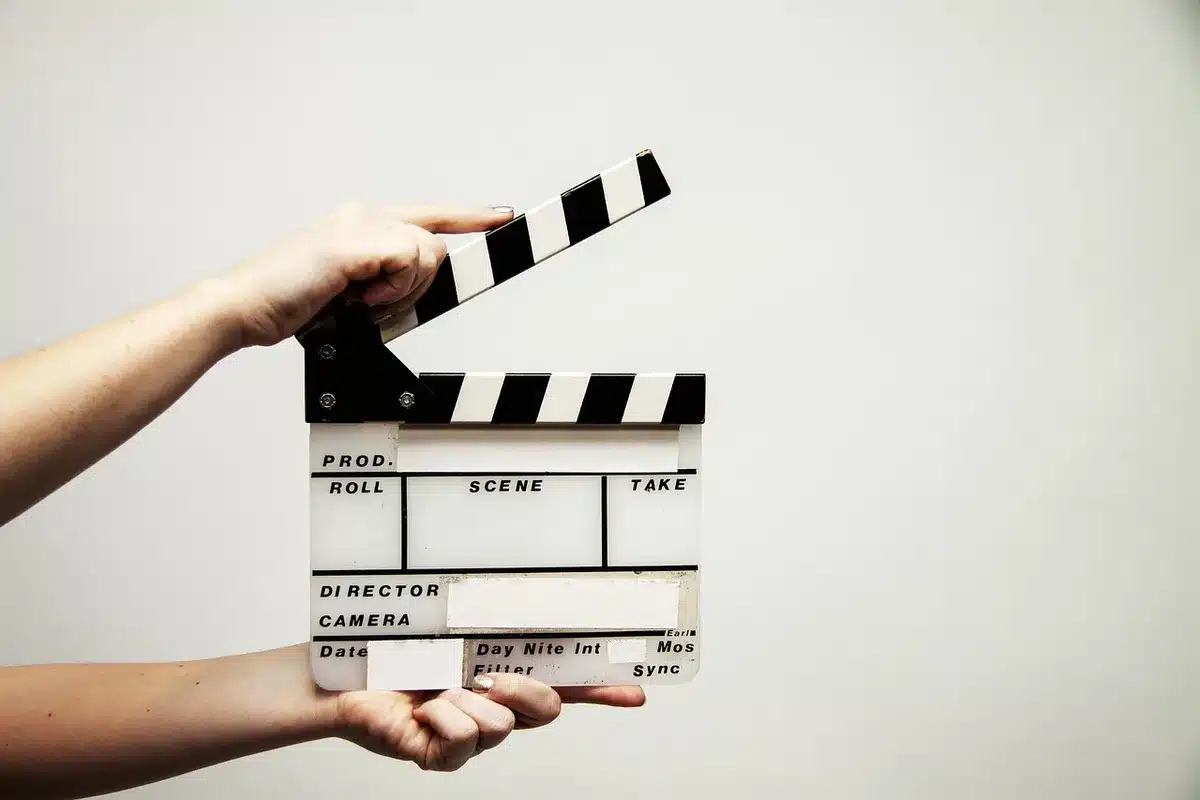 Film set with multiple actors in medieval costume, dramatic lighting on stone set design, cinematic production atmosphere