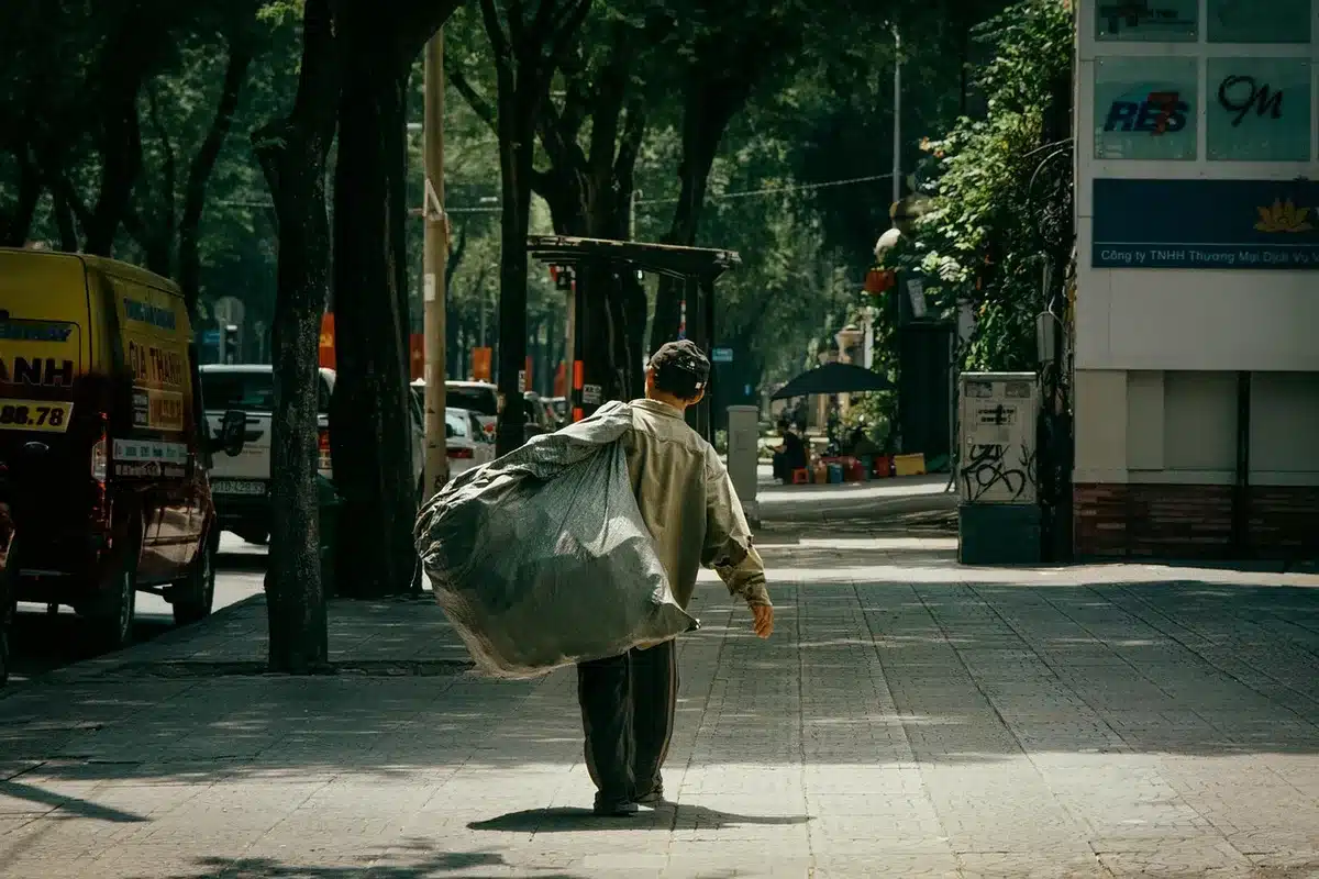A lone figure standing in a dimly lit space, hands in pockets, with a distant gaze and soft lighting creating shadow and depth, suggesting contemplation and emotional processing after a major life change