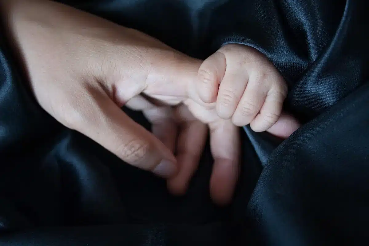 anonymous hands holding a photograph removed from focus on a table, soft light, no faces visible