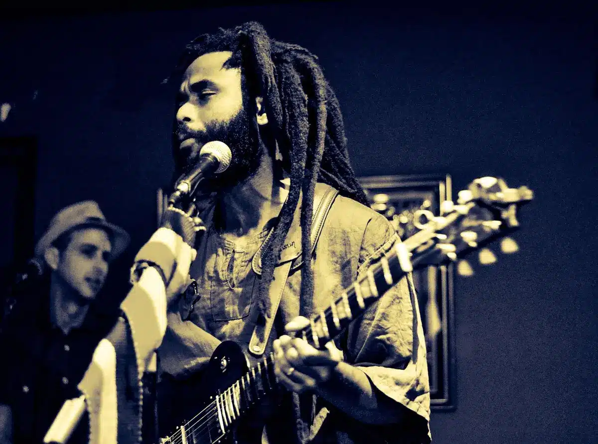 an empty rustic wooden stage with a single vintage microphone under a warm spotlight, dust motes visible in the beam, suggesting intimacy and memory