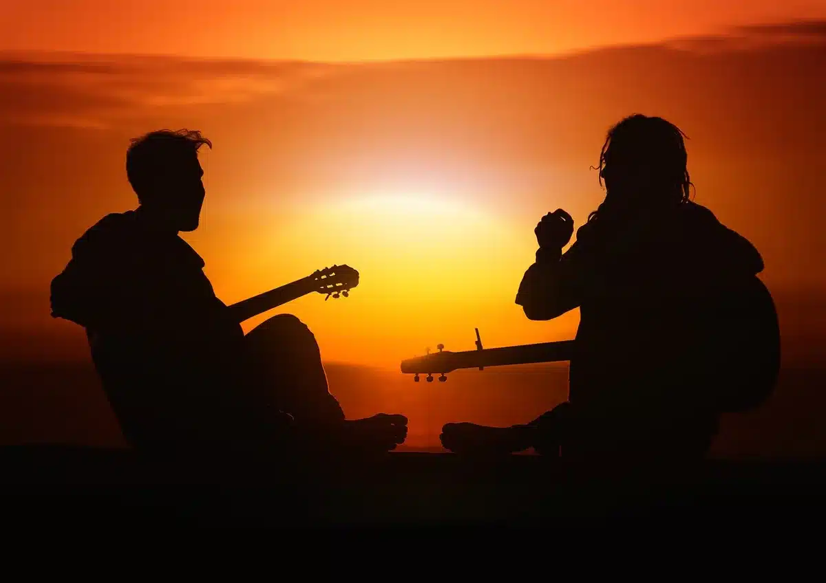 a small group of anonymous musicians on a farm porch at dusk, guitars and a fiddle visible, silhouettes in soft focus evoking nostalgia