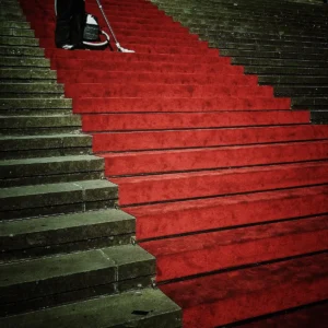 Pôster de filme em cavalete com público anônimo e fundo de tapete vermelho