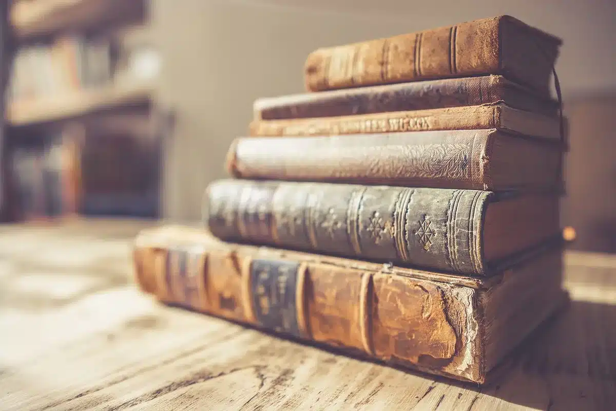 Close-up of a plain hardcover book with no title on the spine, laid on a neutral linen surface with a fountain pen placed diagonally — a preparatory press-copy scene