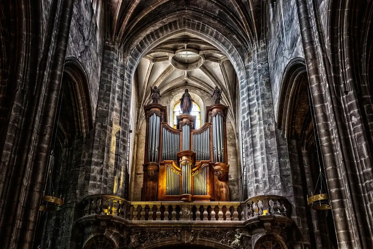 Empty church aisle with floral arrangements and wooden pews prepared for a midday wedding ceremony