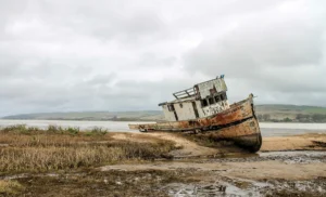 Fragmento de fuselagem e colete salva-vidas flutuando em mar aberto ao amanhecer