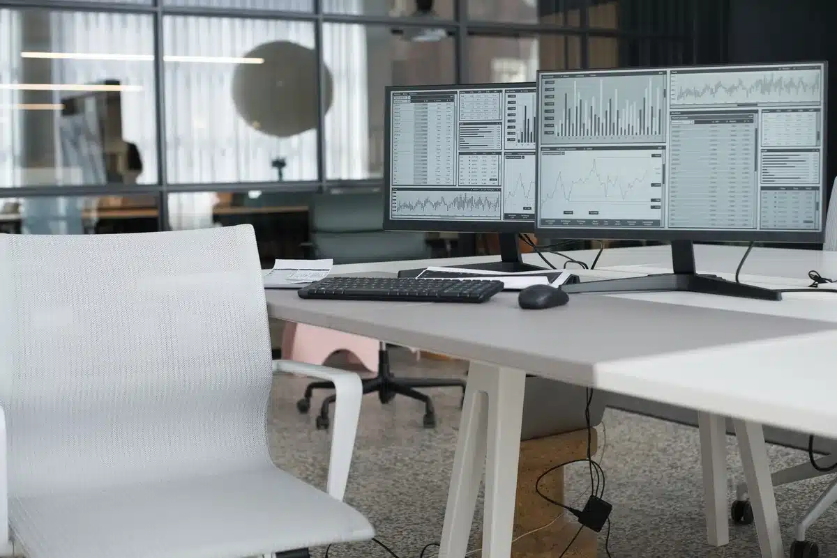 Empty newsroom desk with a single microphone and a turned-off monitor, no logos or identifiable people