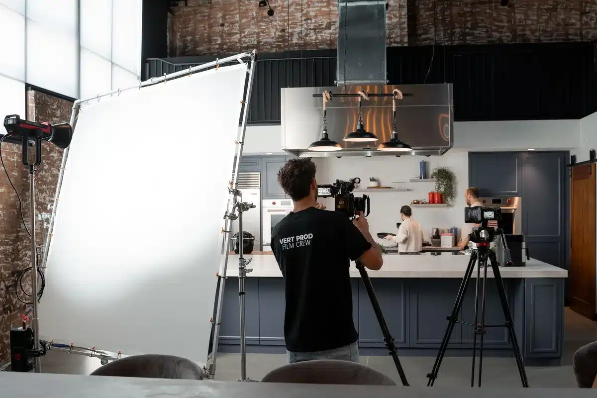empty film set with lighting rigs and a single unbranded chair on set, slate boards blurred in background