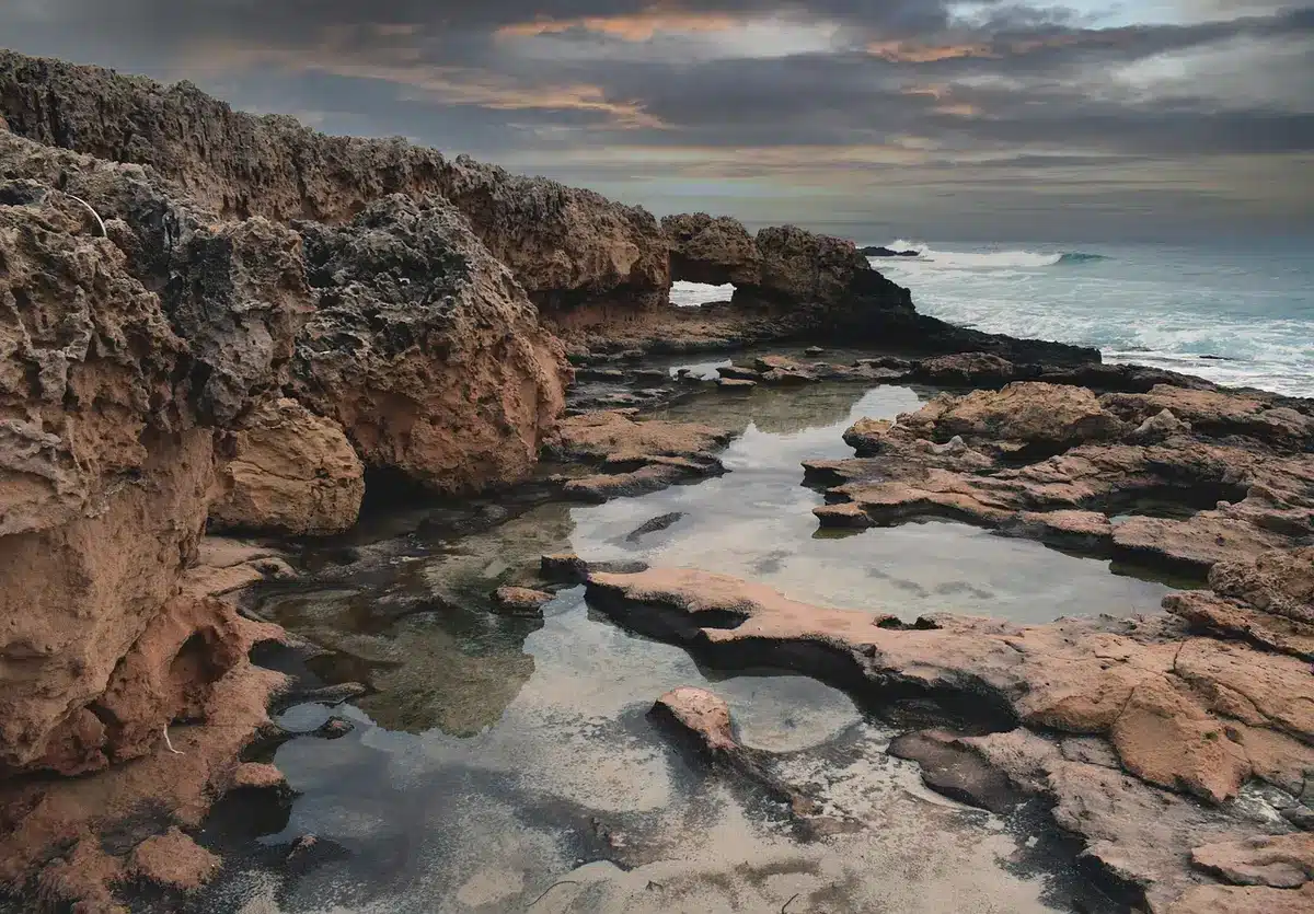 Costa enevoada e mar profundo que sugere mistério nas águas