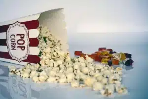 Pessoas anônimas em poltronas de cinema olhando para a tela iluminada