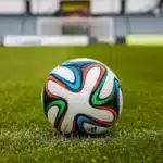 Escritório anônimo de treinador com capacete de futebol e quadro de jogadas