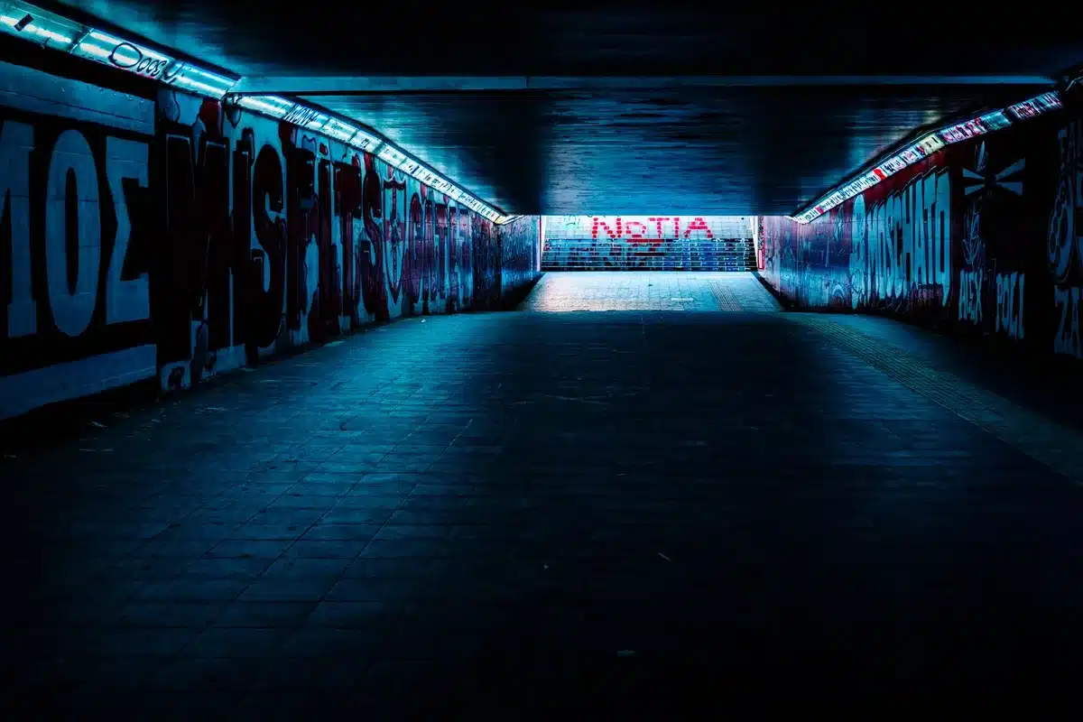 Empty stadium tunnel and a single match ball on the turf, no people, overcast sky